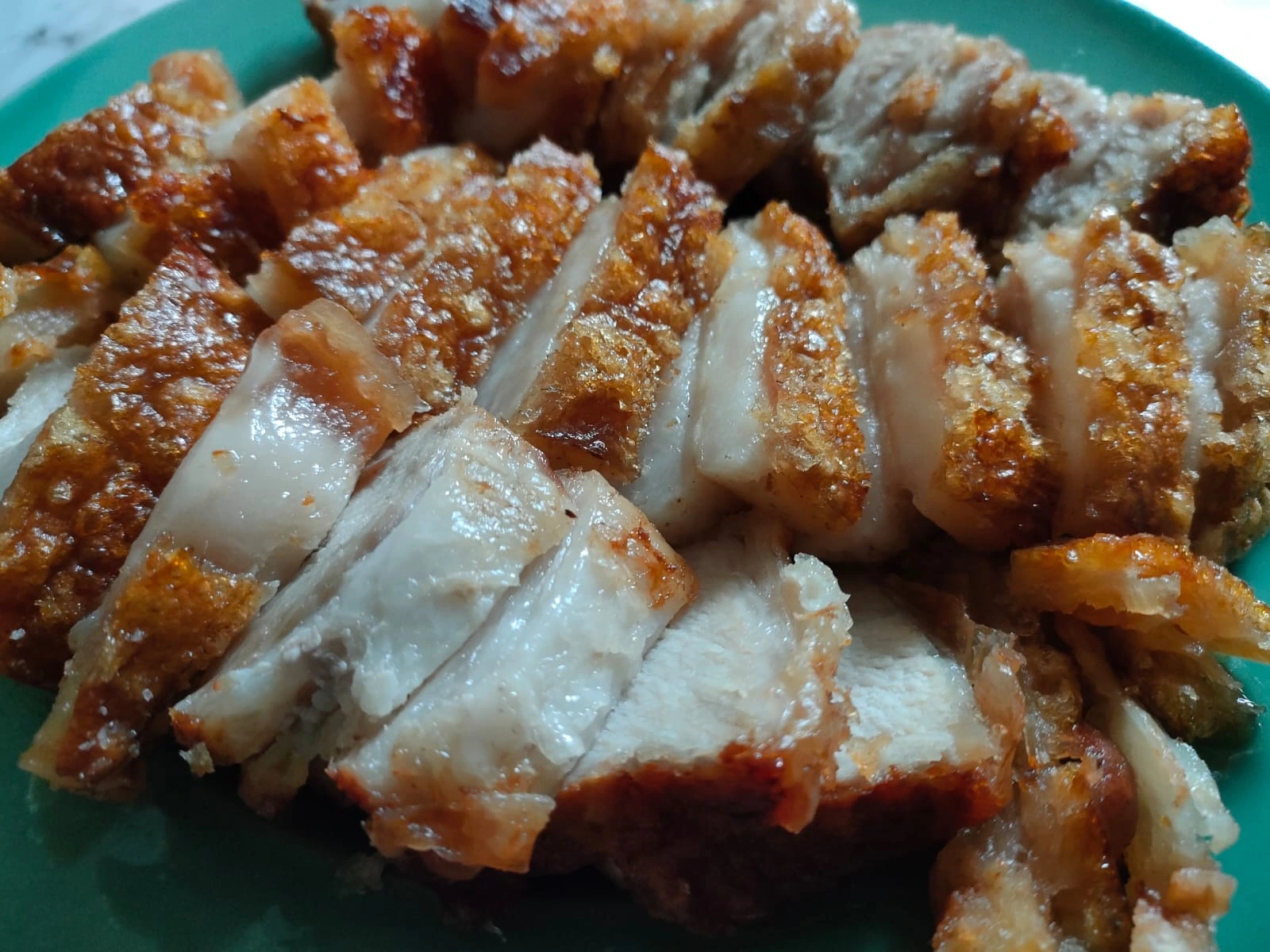 Beautifully plated crispy pork belly (babi panggang krispi) with fresh vegetables
